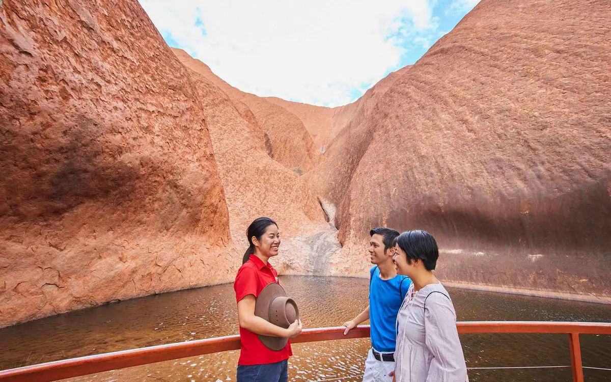 Mutitjulu Waterhole at the foot of Uluru with dark rock walls above the water