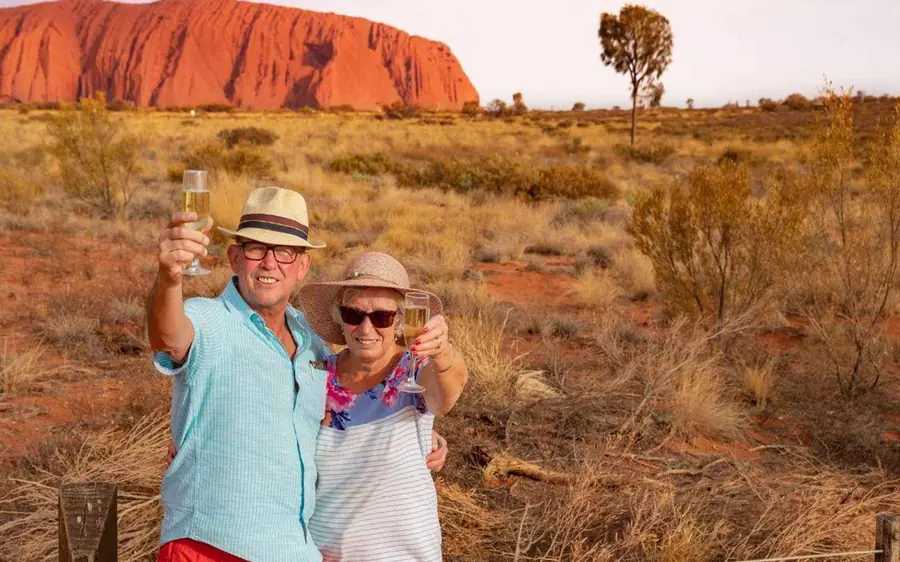 A guide talking to a small group of walkers on a path beside Uluru