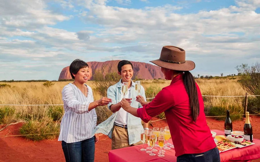 A BBQ dinner laid out on a long table in the desert as the light fades