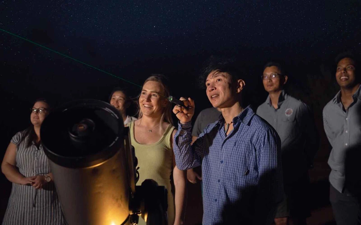 A telescope set up in the desert at night under a dark sky